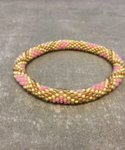 Roll-on armbånd som passer til næsten alle kvinder. Kvindegrupper i Nepal, Kathmandu Valley, udstyres med glasperler og bomuldsgarn, så de i deres fritid kan hækler disse smukke perlearmbånd. Den ekstra indtægt går bl.a. til at sende kvindernes børn i skole. Hvert armbånd er et unikt resultat af kvindernes håndarbejde og varierer i farvekombinationer og mønstre.