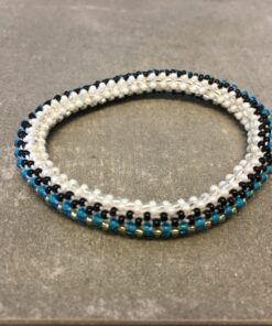 Roll-on armbånd som passer til næsten alle kvinder. Kvindegrupper i Nepal, Kathmandu Valley, udstyres med glasperler og bomuldsgarn, så de i deres fritid kan hækler disse smukke perlearmbånd. Den ekstra indtægt går bl.a. til at sende kvindernes børn i skole. Hvert armbånd er et unikt resultat af kvindernes håndarbejde og varierer i farvekombinationer og mønstre.