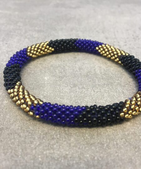 Roll-on armbånd som passer til næsten alle kvinder. Kvindegrupper i Nepal, Kathmandu Valley, udstyres med glasperler og bomuldsgarn, så de i deres fritid kan hækler disse smukke perlearmbånd. Den ekstra indtægt går bl.a. til at sende kvindernes børn i skole. Hvert armbånd er et unikt resultat af kvindernes håndarbejde og varierer i farvekombinationer og mønstre.