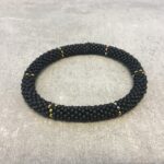 Roll-on armbånd som passer til næsten alle kvinder. Kvindegrupper i Nepal, Kathmandu Valley, udstyres med glasperler og bomuldsgarn, så de i deres fritid kan hækler disse smukke perlearmbånd. Den ekstra indtægt går bl.a. til at sende kvindernes børn i skole. Hvert armbånd er et unikt resultat af kvindernes håndarbejde og varierer i farvekombinationer og mønstre.