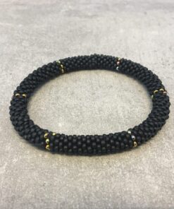 Roll-on armbånd som passer til næsten alle kvinder. Kvindegrupper i Nepal, Kathmandu Valley, udstyres med glasperler og bomuldsgarn, så de i deres fritid kan hækler disse smukke perlearmbånd. Den ekstra indtægt går bl.a. til at sende kvindernes børn i skole. Hvert armbånd er et unikt resultat af kvindernes håndarbejde og varierer i farvekombinationer og mønstre.