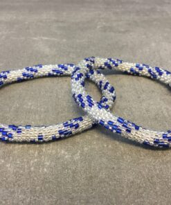 Roll-on armbånd som passer til næsten alle kvinder. Kvindegrupper i Nepal, Kathmandu Valley, udstyres med glasperler og bomuldsgarn, så de i deres fritid kan hækler disse smukke perlearmbånd. Den ekstra indtægt går bl.a. til at sende kvindernes børn i skole. Hvert armbånd er et unikt resultat af kvindernes håndarbejde og varierer i farvekombinationer og mønstre.