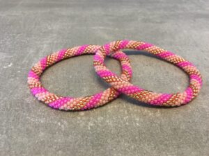 Roll-on perle armbåndene er håndlavet i Nepal. De er lavet med forskellige glasperler og i forskellige mønster. De er hæklet med en bomuldssnor. Syntes man at de lidt stramme, kan man vride forsigtigt i dem så de bliver større. syntes man derimod at de er blive lidt for løse, kan man ligge dem i vand. dette gør at bomildssnoren trækker sig sammen og de bliver mindre igen.