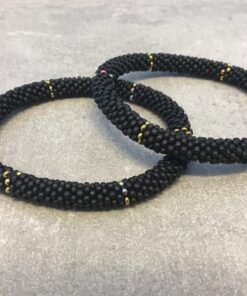 Roll-on armbånd som passer til næsten alle kvinder. Kvindegrupper i Nepal, Kathmandu Valley, udstyres med glasperler og bomuldsgarn, så de i deres fritid kan hækler disse smukke perlearmbånd. Den ekstra indtægt går bl.a. til at sende kvindernes børn i skole. Hvert armbånd er et unikt resultat af kvindernes håndarbejde og varierer i farvekombinationer og mønstre.