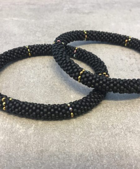 Roll-on armbånd som passer til næsten alle kvinder. Kvindegrupper i Nepal, Kathmandu Valley, udstyres med glasperler og bomuldsgarn, så de i deres fritid kan hækler disse smukke perlearmbånd. Den ekstra indtægt går bl.a. til at sende kvindernes børn i skole. Hvert armbånd er et unikt resultat af kvindernes håndarbejde og varierer i farvekombinationer og mønstre.