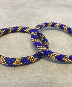 Roll-on armbånd som passer til næsten alle kvinder. Kvindegrupper i Nepal, Kathmandu Valley, udstyres med glasperler og bomuldsgarn, så de i deres fritid kan hækler disse smukke perlearmbånd. Den ekstra indtægt går bl.a. til at sende kvindernes børn i skole. Hvert armbånd er et unikt resultat af kvindernes håndarbejde og varierer i farvekombinationer og mønstre.