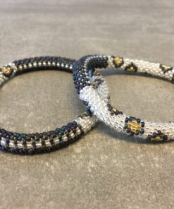 Roll-on perle armbåndene er håndlavet i Nepal. De er lavet med forskellige glasperler og i forskellige mønster. De er hæklet med en bomuldssnor. Syntes man at de lidt stramme, kan man vride forsigtigt i dem så de bliver større. syntes man derimod at de er blive lidt for løse, kan man ligge dem i vand. dette gør at bomildssnoren trækker sig sammen og de bliver mindre igen.