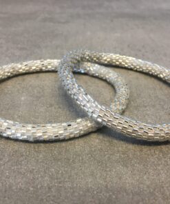 Roll-on armbånd som passer til næsten alle kvinder. Kvindegrupper i Nepal, Kathmandu Valley, udstyres med glasperler og bomuldsgarn, så de i deres fritid kan hækler disse smukke perlearmbånd. Den ekstra indtægt går bl.a. til at sende kvindernes børn i skole. Hvert armbånd er et unikt resultat af kvindernes håndarbejde og varierer i farvekombinationer og mønstre.