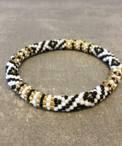 Roll-on armbånd som passer til næsten alle kvinder. Kvindegrupper i Nepal, Kathmandu Valley, udstyres med glasperler og bomuldsgarn, så de i deres fritid kan hækler disse smukke perlearmbånd. Den ekstra indtægt går bl.a. til at sende kvindernes børn i skole. Hvert armbånd er et unikt resultat af kvindernes håndarbejde og varierer i farvekombinationer og mønstre.