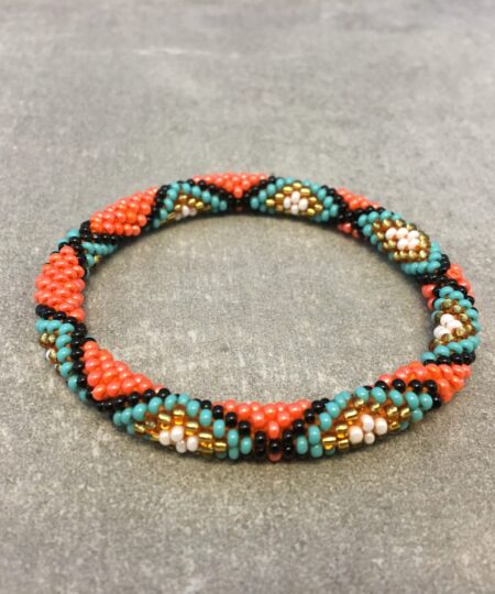 Roll-on armbånd som passer til næsten alle kvinder. Kvindegrupper i Nepal, Kathmandu Valley, udstyres med glasperler og bomuldsgarn, så de i deres fritid kan hækler disse smukke perlearmbånd. Den ekstra indtægt går bl.a. til at sende kvindernes børn i skole. Hvert armbånd er et unikt resultat af kvindernes håndarbejde og varierer i farvekombinationer og mønstre.