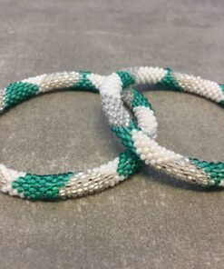 Roll-on perle armbåndene er håndlavet i Nepal. De er lavet med forskellige glasperler og i forskellige mønster. De er hæklet med en bomuldssnor. Syntes man at de lidt stramme, kan man vride forsigtigt i dem så de bliver større. syntes man derimod at de er blive lidt for løse, kan man ligge dem i vand. dette gør at bomildssnoren trækker sig sammen og de bliver mindre igen.