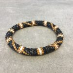 Roll-on armbånd som passer til næsten alle kvinder. Kvindegrupper i Nepal, Kathmandu Valley, udstyres med glasperler og bomuldsgarn, så de i deres fritid kan hækler disse smukke perlearmbånd. Den ekstra indtægt går bl.a. til at sende kvindernes børn i skole. Hvert armbånd er et unikt resultat af kvindernes håndarbejde og varierer i farvekombinationer og mønstre.