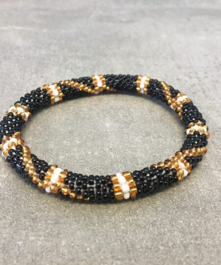 Roll-on armbånd som passer til næsten alle kvinder. Kvindegrupper i Nepal, Kathmandu Valley, udstyres med glasperler og bomuldsgarn, så de i deres fritid kan hækler disse smukke perlearmbånd. Den ekstra indtægt går bl.a. til at sende kvindernes børn i skole. Hvert armbånd er et unikt resultat af kvindernes håndarbejde og varierer i farvekombinationer og mønstre.