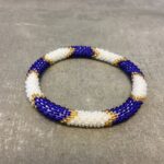 Roll-on armbånd som passer til næsten alle kvinder. Kvindegrupper i Nepal, Kathmandu Valley, udstyres med glasperler og bomuldsgarn, så de i deres fritid kan hækler disse smukke perlearmbånd. Den ekstra indtægt går bl.a. til at sende kvindernes børn i skole. Hvert armbånd er et unikt resultat af kvindernes håndarbejde og varierer i farvekombinationer og mønstre.