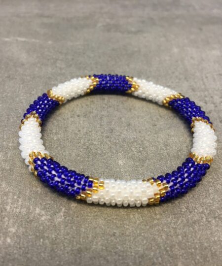 Roll-on armbånd som passer til næsten alle kvinder. Kvindegrupper i Nepal, Kathmandu Valley, udstyres med glasperler og bomuldsgarn, så de i deres fritid kan hækler disse smukke perlearmbånd. Den ekstra indtægt går bl.a. til at sende kvindernes børn i skole. Hvert armbånd er et unikt resultat af kvindernes håndarbejde og varierer i farvekombinationer og mønstre.