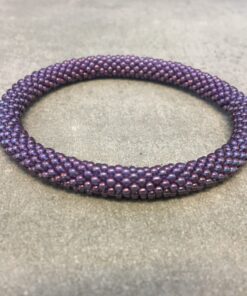 Roll-on armbånd som passer til næsten alle kvinder. Kvindegrupper i Nepal, Kathmandu Valley, udstyres med glasperler og bomuldsgarn, så de i deres fritid kan hækler disse smukke perlearmbånd. Den ekstra indtægt går bl.a. til at sende kvindernes børn i skole. Hvert armbånd er et unikt resultat af kvindernes håndarbejde og varierer i farvekombinationer og mønstre.