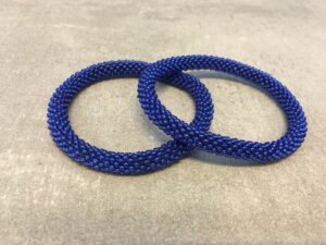 Roll-on perle armbåndene er håndlavet i Nepal. De er lavet med forskellige glasperler og i forskellige mønster. De er hæklet med en bomuldssnor. Syntes man at de lidt stramme, kan man vride forsigtigt i dem så de bliver større. syntes man derimod at de er blive lidt for løse, kan man ligge dem i vand. dette gør at bomildssnoren trækker sig sammen og de bliver mindre igen.