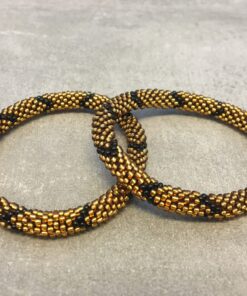 Roll-on armbånd som passer til næsten alle kvinder. Kvindegrupper i Nepal, Kathmandu Valley, udstyres med glasperler og bomuldsgarn, så de i deres fritid kan hækler disse smukke perlearmbånd. Den ekstra indtægt går bl.a. til at sende kvindernes børn i skole. Hvert armbånd er et unikt resultat af kvindernes håndarbejde og varierer i farvekombinationer og mønstre.