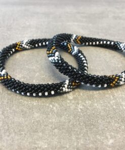 Roll-on armbånd som passer til næsten alle kvinder. Kvindegrupper i Nepal, Kathmandu Valley, udstyres med glasperler og bomuldsgarn, så de i deres fritid kan hækler disse smukke perlearmbånd. Den ekstra indtægt går bl.a. til at sende kvindernes børn i skole. Hvert armbånd er et unikt resultat af kvindernes håndarbejde og varierer i farvekombinationer og mønstre.