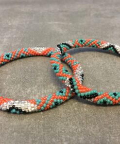 Roll-on armbånd som passer til næsten alle kvinder. Kvindegrupper i Nepal, Kathmandu Valley, udstyres med glasperler og bomuldsgarn, så de i deres fritid kan hækler disse smukke perlearmbånd. Den ekstra indtægt går bl.a. til at sende kvindernes børn i skole. Hvert armbånd er et unikt resultat af kvindernes håndarbejde og varierer i farvekombinationer og mønstre.