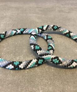 Roll-on armbånd som passer til næsten alle kvinder. Kvindegrupper i Nepal, Kathmandu Valley, udstyres med glasperler og bomuldsgarn, så de i deres fritid kan hækler disse smukke perlearmbånd. Den ekstra indtægt går bl.a. til at sende kvindernes børn i skole. Hvert armbånd er et unikt resultat af kvindernes håndarbejde og varierer i farvekombinationer og mønstre.