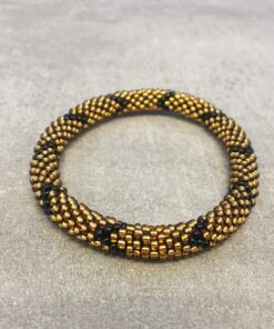 Roll-on armbånd som passer til næsten alle kvinder. Kvindegrupper i Nepal, Kathmandu Valley, udstyres med glasperler og bomuldsgarn, så de i deres fritid kan hækler disse smukke perlearmbånd. Den ekstra indtægt går bl.a. til at sende kvindernes børn i skole. Hvert armbånd er et unikt resultat af kvindernes håndarbejde og varierer i farvekombinationer og mønstre.