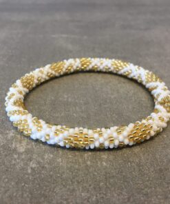 Roll-on armbånd som passer til næsten alle kvinder. Kvindegrupper i Nepal, Kathmandu Valley, udstyres med glasperler og bomuldsgarn, så de i deres fritid kan hækler disse smukke perlearmbånd. Den ekstra indtægt går bl.a. til at sende kvindernes børn i skole. Hvert armbånd er et unikt resultat af kvindernes håndarbejde og varierer i farvekombinationer og mønstre.