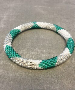 Roll-on armbånd som passer til næsten alle kvinder. Kvindegrupper i Nepal, Kathmandu Valley, udstyres med glasperler og bomuldsgarn, så de i deres fritid kan hækler disse smukke perlearmbånd. Den ekstra indtægt går bl.a. til at sende kvindernes børn i skole. Hvert armbånd er et unikt resultat af kvindernes håndarbejde og varierer i farvekombinationer og mønstre.