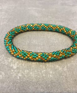 Roll-on armbånd som passer til næsten alle kvinder. Kvindegrupper i Nepal, Kathmandu Valley, udstyres med glasperler og bomuldsgarn, så de i deres fritid kan hækler disse smukke perlearmbånd. Den ekstra indtægt går bl.a. til at sende kvindernes børn i skole. Hvert armbånd er et unikt resultat af kvindernes håndarbejde og varierer i farvekombinationer og mønstre.