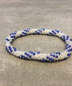 Roll-on armbånd som passer til næsten alle kvinder. Kvindegrupper i Nepal, Kathmandu Valley, udstyres med glasperler og bomuldsgarn, så de i deres fritid kan hækler disse smukke perlearmbånd. Den ekstra indtægt går bl.a. til at sende kvindernes børn i skole. Hvert armbånd er et unikt resultat af kvindernes håndarbejde og varierer i farvekombinationer og mønstre.