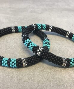 Roll-on armbånd som passer til næsten alle kvinder. Kvindegrupper i Nepal, Kathmandu Valley, udstyres med glasperler og bomuldsgarn, så de i deres fritid kan hækler disse smukke perlearmbånd. Den ekstra indtægt går bl.a. til at sende kvindernes børn i skole. Hvert armbånd er et unikt resultat af kvindernes håndarbejde og varierer i farvekombinationer og mønstre.