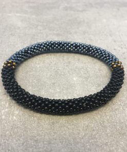 Roll-on armbånd som passer til næsten alle kvinder. Kvindegrupper i Nepal, Kathmandu Valley, udstyres med glasperler og bomuldsgarn, så de i deres fritid kan hækler disse smukke perlearmbånd. Den ekstra indtægt går bl.a. til at sende kvindernes børn i skole. Hvert armbånd er et unikt resultat af kvindernes håndarbejde og varierer i farvekombinationer og mønstre.