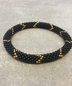 Roll-on armbånd som passer til næsten alle kvinder. Kvindegrupper i Nepal, Kathmandu Valley, udstyres med glasperler og bomuldsgarn, så de i deres fritid kan hækler disse smukke perlearmbånd. Den ekstra indtægt går bl.a. til at sende kvindernes børn i skole. Hvert armbånd er et unikt resultat af kvindernes håndarbejde og varierer i farvekombinationer og mønstre.