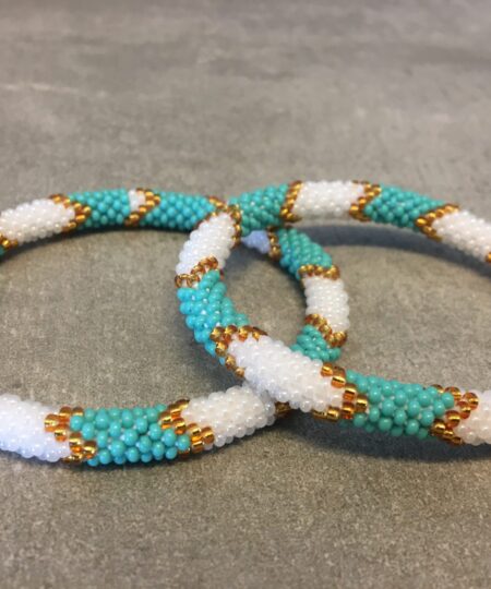 Roll-on perle armbåndene er håndlavet i Nepal. De er lavet med forskellige glasperler og i forskellige mønster. De er hæklet med en bomuldssnor. Syntes man at de lidt stramme, kan man vride forsigtigt i dem så de bliver større. syntes man derimod at de er blive lidt for løse, kan man ligge dem i vand. dette gør at bomildssnoren trækker sig sammen og de bliver mindre igen.