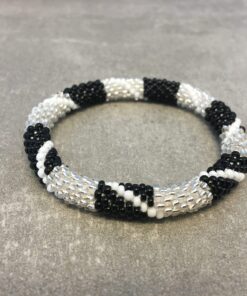 Roll-on armbånd som passer til næsten alle kvinder. Kvindegrupper i Nepal, Kathmandu Valley, udstyres med glasperler og bomuldsgarn, så de i deres fritid kan hækler disse smukke perlearmbånd. Den ekstra indtægt går bl.a. til at sende kvindernes børn i skole. Hvert armbånd er et unikt resultat af kvindernes håndarbejde og varierer i farvekombinationer og mønstre.