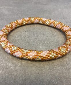 Roll-on armbånd som passer til næsten alle kvinder. Kvindegrupper i Nepal, Kathmandu Valley, udstyres med glasperler og bomuldsgarn, så de i deres fritid kan hækler disse smukke perlearmbånd. Den ekstra indtægt går bl.a. til at sende kvindernes børn i skole. Hvert armbånd er et unikt resultat af kvindernes håndarbejde og varierer i farvekombinationer og mønstre.