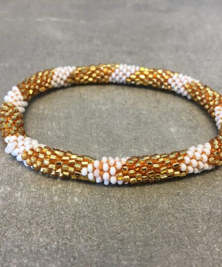 Roll-on armbånd som passer til næsten alle kvinder. Kvindegrupper i Nepal, Kathmandu Valley, udstyres med glasperler og bomuldsgarn, så de i deres fritid kan hækler disse smukke perlearmbånd. Den ekstra indtægt går bl.a. til at sende kvindernes børn i skole. Hvert armbånd er et unikt resultat af kvindernes håndarbejde og varierer i farvekombinationer og mønstre.