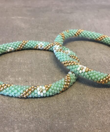 Roll-on perle armbåndene er håndlavet i Nepal. De er lavet med forskellige glasperler og i forskellige mønster. De er hæklet med en bomuldssnor. Syntes man at de lidt stramme, kan man vride forsigtigt i dem så de bliver større. syntes man derimod at de er blive lidt for løse, kan man ligge dem i vand. dette gør at bomildssnoren trækker sig sammen og de bliver mindre igen.