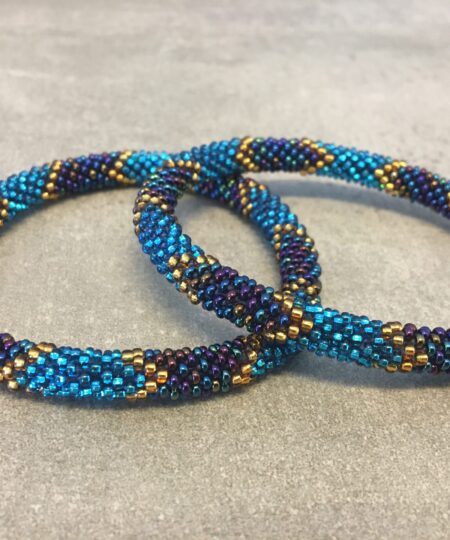 Roll-on perle armbåndene er håndlavet i Nepal. De er lavet med forskellige glasperler og i forskellige mønster. De er hæklet med en bomuldssnor. Syntes man at de lidt stramme, kan man vride forsigtigt i dem så de bliver større. syntes man derimod at de er blive lidt for løse, kan man ligge dem i vand. dette gør at bomildssnoren trækker sig sammen og de bliver mindre igen.