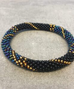 Roll-on armbånd som passer til næsten alle kvinder. Kvindegrupper i Nepal, Kathmandu Valley, udstyres med glasperler og bomuldsgarn, så de i deres fritid kan hækler disse smukke perlearmbånd. Den ekstra indtægt går bl.a. til at sende kvindernes børn i skole. Hvert armbånd er et unikt resultat af kvindernes håndarbejde og varierer i farvekombinationer og mønstre.