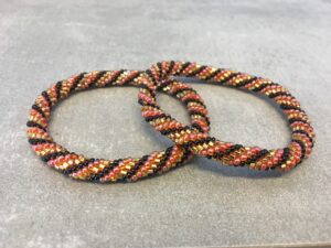 Roll-on perle armbåndene er håndlavet i Nepal. De er lavet med forskellige glasperler og i forskellige mønster. De er hæklet med en bomuldssnor. Syntes man at de lidt stramme, kan man vride forsigtigt i dem så de bliver større. syntes man derimod at de er blive lidt for løse, kan man ligge dem i vand. dette gør at bomildssnoren trækker sig sammen og de bliver mindre igen.