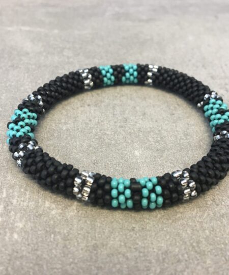 Roll-on armbånd som passer til næsten alle kvinder. Kvindegrupper i Nepal, Kathmandu Valley, udstyres med glasperler og bomuldsgarn, så de i deres fritid kan hækler disse smukke perlearmbånd. Den ekstra indtægt går bl.a. til at sende kvindernes børn i skole. Hvert armbånd er et unikt resultat af kvindernes håndarbejde og varierer i farvekombinationer og mønstre.