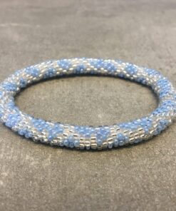 Roll-on armbånd som passer til næsten alle kvinder. Kvindegrupper i Nepal, Kathmandu Valley, udstyres med glasperler og bomuldsgarn, så de i deres fritid kan hækler disse smukke perlearmbånd. Den ekstra indtægt går bl.a. til at sende kvindernes børn i skole. Hvert armbånd er et unikt resultat af kvindernes håndarbejde og varierer i farvekombinationer og mønstre.