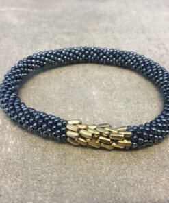 Roll-on armbånd som passer til næsten alle kvinder. Kvindegrupper i Nepal, Kathmandu Valley, udstyres med glasperler og bomuldsgarn, så de i deres fritid kan hækler disse smukke perlearmbånd. Den ekstra indtægt går bl.a. til at sende kvindernes børn i skole. Hvert armbånd er et unikt resultat af kvindernes håndarbejde og varierer i farvekombinationer og mønstre.