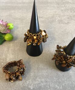 Ringe lavet af natursten er unikke og smukke smykker, der udstråler en tidløs elegance. Med deres naturlige farver og mønstre, bringer de et strejf af naturen ind i smykkeverdenen. Hver ring er enestående, da naturstenenes variationer gør, at ingen to ringe er helt ens. Natursten som fx agat, ametyst, turmalin, eller jaspis bliver omhyggeligt udvalgt og slebet til den ønskede form. Disse sten kan have dybe, intense farver eller mere subtile nuancer, alt efter stenens oprindelse og egenskaber. Det skaber en bred vifte af valgmuligheder for folk med forskellige smag og præferencer. Udover deres æstetiske skønhed, er ringe lavet af natursten også kendt for deres symbolske betydning. Nogle tror, at forskellige sten har specifikke egenskaber eller energier, der kan påvirke bæreren positivt. For eksempel siges ametyst at fremme indre ro og visdom, mens turmalin menes at beskytte mod negativ energi. En ring lavet af natursten er ikke kun et smykke, men også et kunstværk, der bærer naturens skønhed med sig. De er perfekte som personlige gaver til særlige anledninger eller som en måde at forbinde med naturen og dens mysterier. Uanset om det er til hverdag eller fest, tilføjer en ring lavet af natursten en subtil elegance til ethvert outfit. Den naturlige glans og unikke tekstur i stenen skaber et iøjnefaldende fokus, der vil tiltrække opmærksomhed og beundring. Kort sagt, ringe lavet af natursten er et smukt valg for dem, der søger et unikt smykke med en særlig forbindelse til naturen og dens vidundere. Deres tidløse skønhed og symbolske betydning gør dem til en varig favorit blandt smykkeelskere verden over.