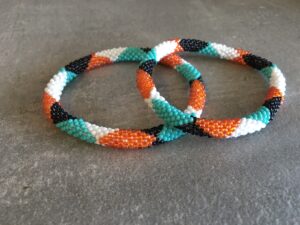 Roll-on perle armbåndene er håndlavet i Nepal. De er lavet med forskellige glasperler og i forskellige mønster. De er hæklet med en bomuldssnor. Syntes man at de lidt stramme, kan man vride forsigtigt i dem så de bliver større. syntes man derimod at de er blive lidt for løse, kan man ligge dem i vand. dette gør at bomildssnoren trækker sig sammen og de bliver mindre igen.