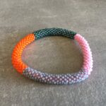 Roll-on perle armbåndene er håndlavet i Nepal. De er lavet med forskellige glasperler og i forskellige mønster. De er hæklet med en bomuldssnor. Syntes man at de lidt stramme, kan man vride forsigtigt i dem så de bliver større. syntes man derimod at de er blive lidt for løse, kan man ligge dem i vand. dette gør at bomildssnoren trækker sig sammen og de bliver mindre igen.