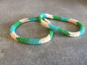 Roll-on perle armbåndene er håndlavet i Nepal. De er lavet med forskellige glasperler og i forskellige mønster. De er hæklet med en bomuldssnor. Syntes man at de lidt stramme, kan man vride forsigtigt i dem så de bliver større. syntes man derimod at de er blive lidt for løse, kan man ligge dem i vand. dette gør at bomildssnoren trækker sig sammen og de bliver mindre igen.