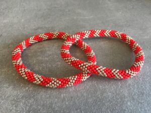 Roll-on perle armbåndene er håndlavet i Nepal. De er lavet med forskellige glasperler og i forskellige mønster. De er hæklet med en bomuldssnor. Syntes man at de lidt stramme, kan man vride forsigtigt i dem så de bliver større. syntes man derimod at de er blive lidt for løse, kan man ligge dem i vand. dette gør at bomildssnoren trækker sig sammen og de bliver mindre igen.