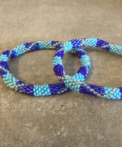 Roll-on perle armbåndene er håndlavet i Nepal. De er lavet med forskellige glasperler og i forskellige mønster. De er hæklet med en bomuldssnor. Syntes man at de lidt stramme, kan man vride forsigtigt i dem så de bliver større. syntes man derimod at de er blive lidt for løse, kan man ligge dem i vand. dette gør at bomildssnoren trækker sig sammen og de bliver mindre igen.